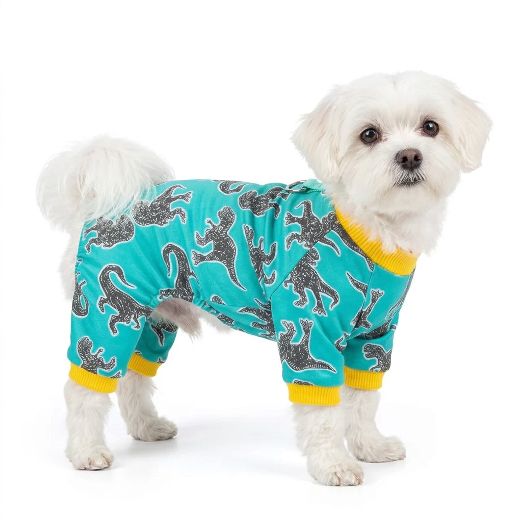 Maltese wearing green dinosaur print dog pajamas